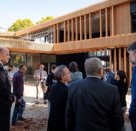 Ceci est une photo où l'on voit des élus au premier plan lors de l'inauguration du bâtiment, qui est lui visible au second plan